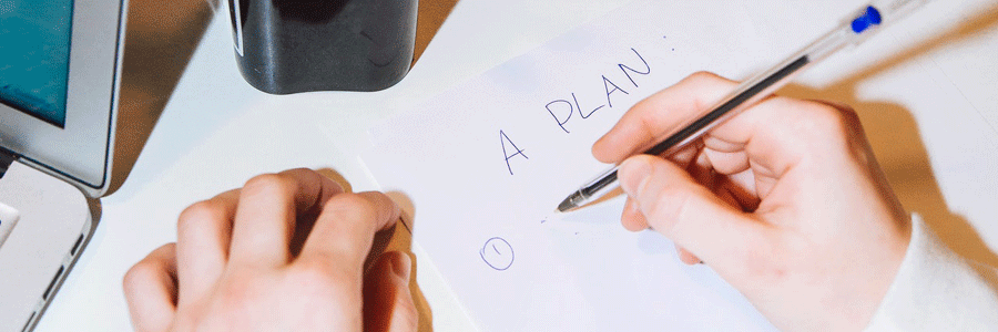 Close-up of person writing a plan