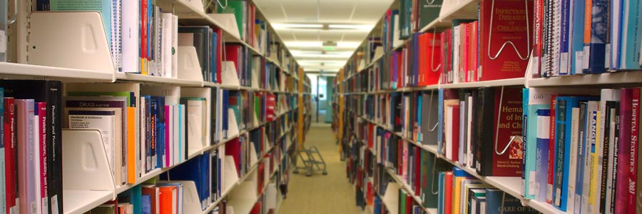An aisle of bookshelves inside the CDC's Information Center, a public health-related library.