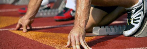 close-up of a runner's arms and legs at the starting mark