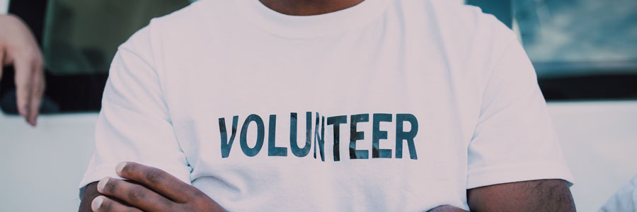 person wearing a white shirt with the word "volunteer" on the chest