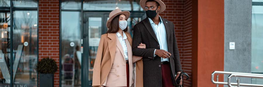 Couple walking out of a building wearing masks