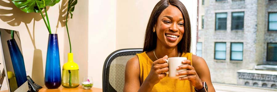 Lady smiling and holding a cup of coffee
