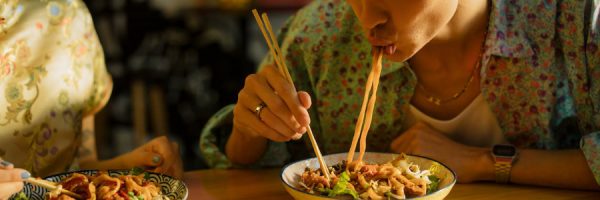 Man eating a plate of noodles
